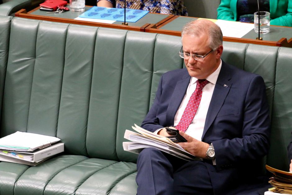 Scott Morrison is using his smart phone in parliement