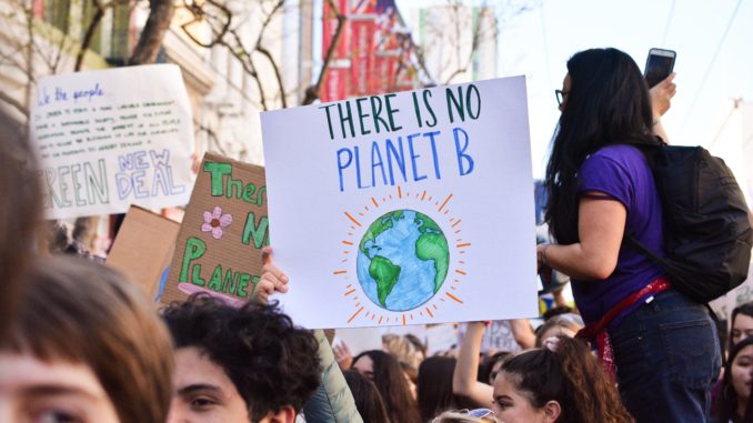 A poster calling for climate action is held by a protester