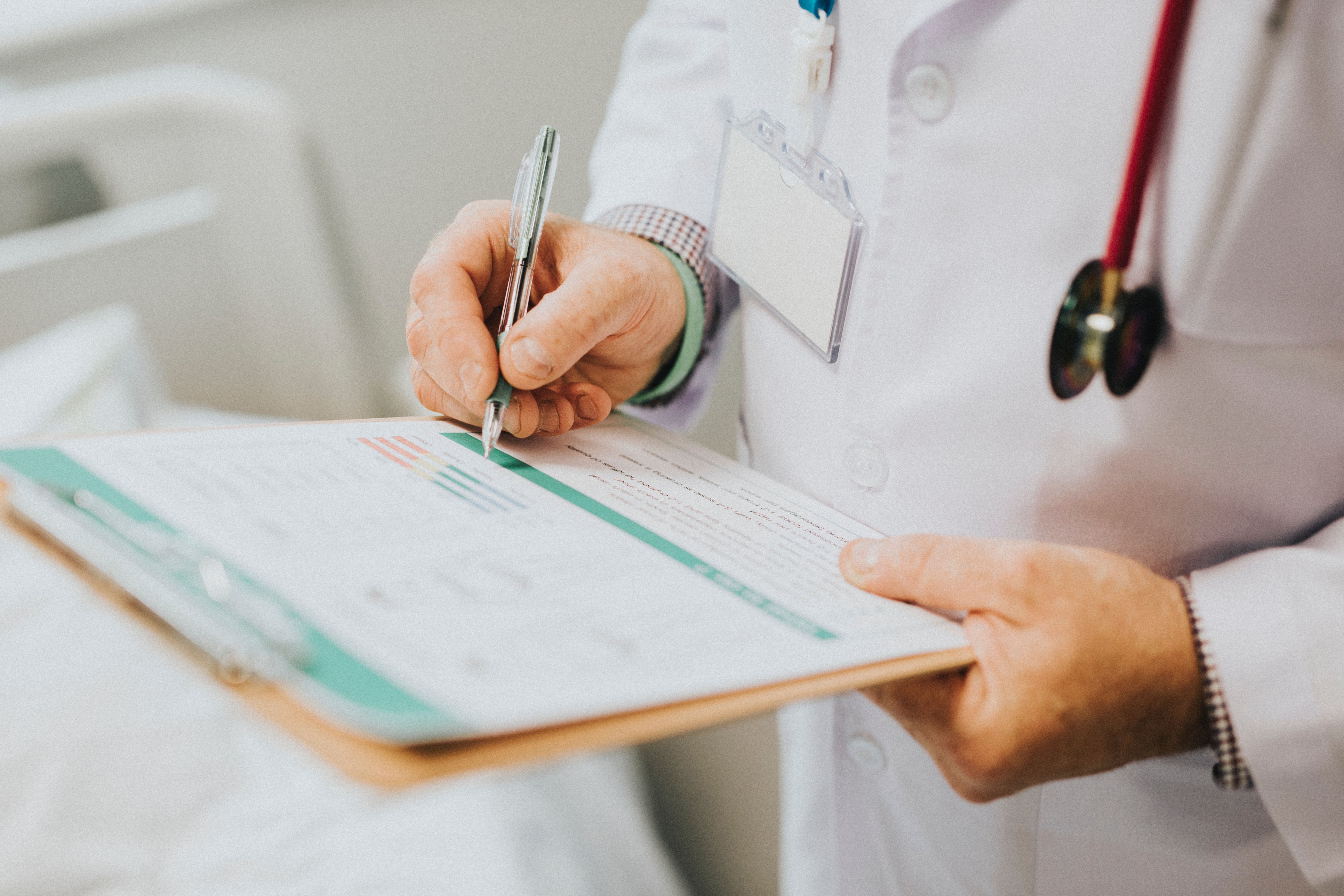 Doctor is taking notes on health condition of the patient. 