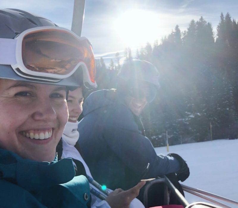 Three people on chair lift smiling