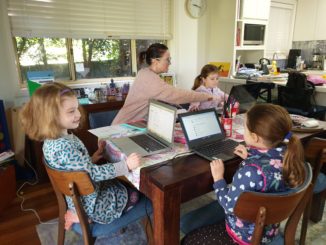 Mother working at home with three kids, all with laptops.