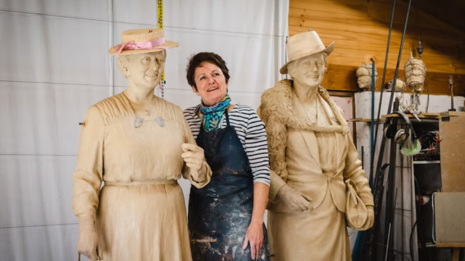 features Artist Lis Johnson stands with her sculptures of the women.(NCA: Dom Northcott)