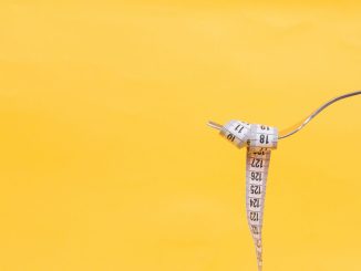 A yellow background with a fork and a measurement tape