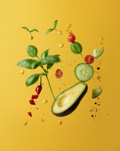 Yellow background with green vegetables and food