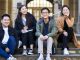 Chinese international students sit fornt the arch of taching building university