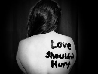 love shouldn't hurt-printed on back of woman, by Sydney Sims, via Unsplash