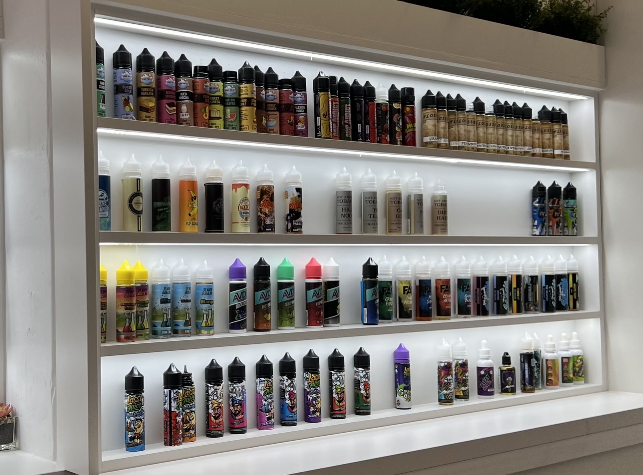 Coloured vape pods of different flavours on the wall.