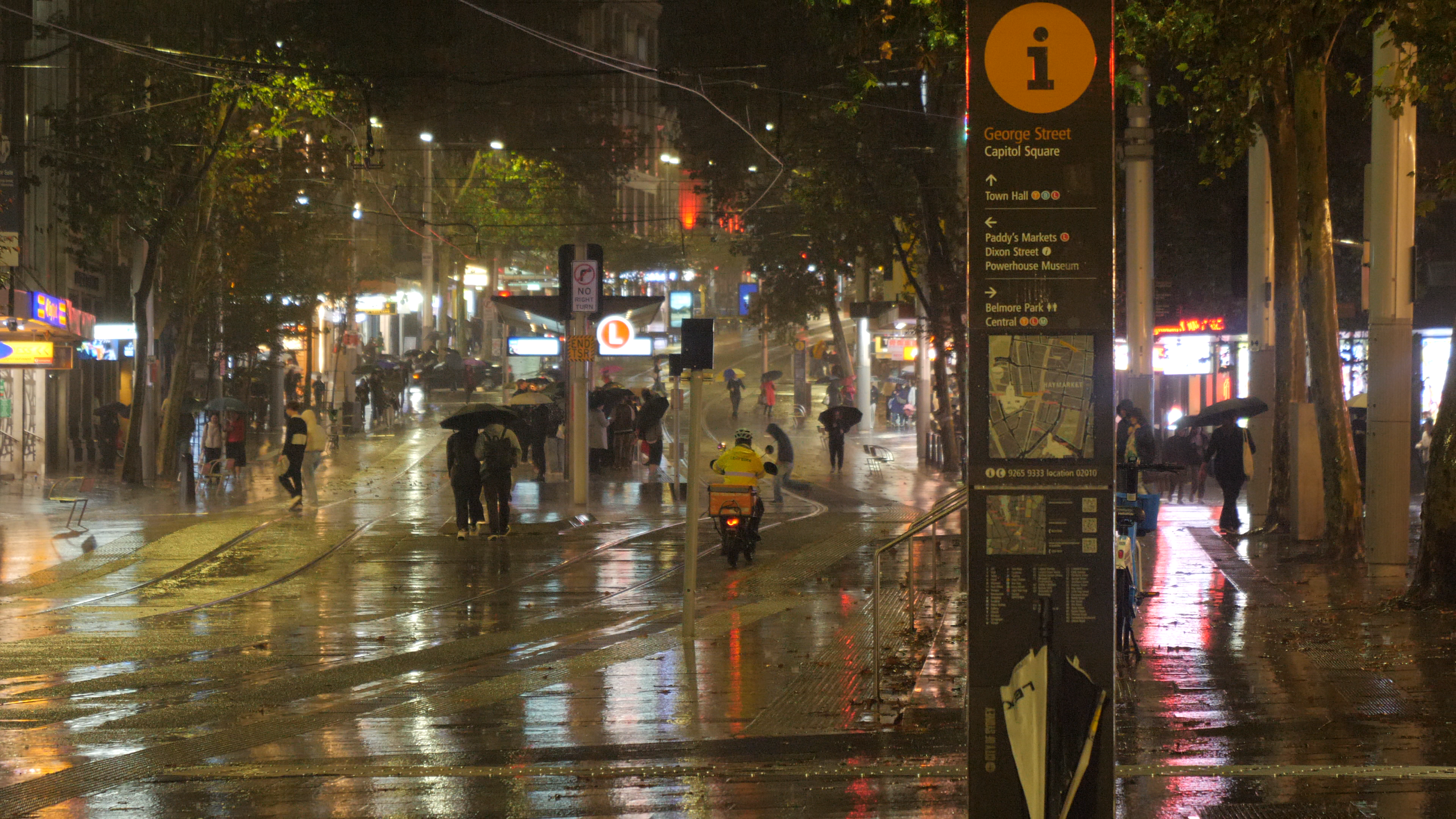 Riders delivering in Sydney’s CBD on a rainy night. Photo by Lyn Zhan