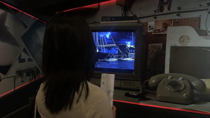 Nan Su watches a video introducing the HMAS Vampire vessel.