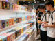 Several students shake blind boxes at the Pop Mart shelves, hesitating over which one to buy